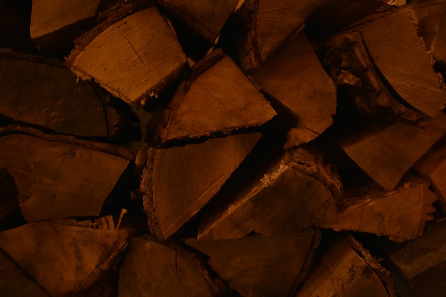 Bûches de bois de chauffage fendues empilées avec une écorce rugueuse visible.